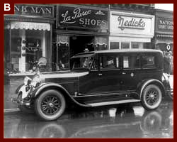 Presidential automobile, ca. 1924 Lincoln, parked in front of stores, with the chauffeur seated behind the steering wheel