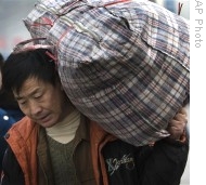 A migrant worker carries his bag as he leaves the Beijing Railway Station, in Beijing, 16 Jan 2009