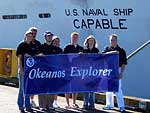 Woodstock High winiing student team holds Okeanos Explorer banner in fron of former Navy ship Capable