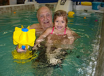 Adolph Kiefer and his great granddaughter in a swimming pool
