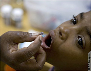 Child opening mouth to receive pill (AP Images)