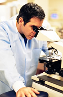 Photo of man looking into microscope