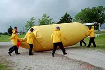 TELEX team members maneuver the launch tube containing the inflated balloon into position