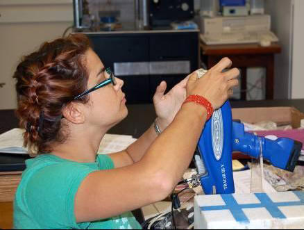 Caitlin O'Grady examines portable x-ray fluorescence spetrograph.