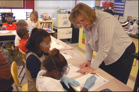 Mary Striegel discusses a chemistry activity with students.