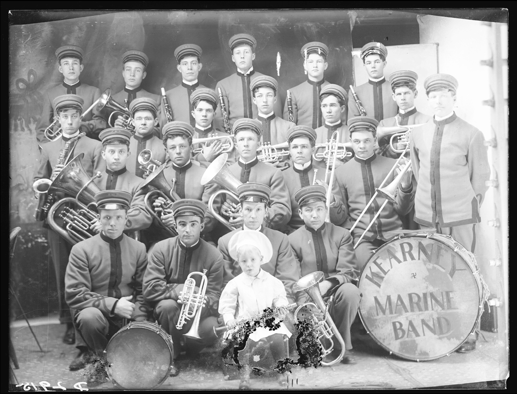 Kearney Marine Band circa 1912. Though taken in a studio, this image contained several promising reflections in musical instruments and the brims of caps.