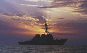Silhouette of naval ship at sunset.
