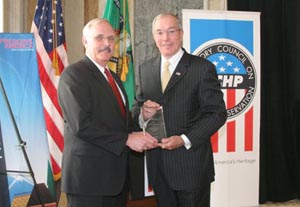 James A. Thomas, Director of the Office of Facilities and Support Services at the Department of the Treasury, receives the crystal award from ACHP Chairman John L. Nau, III