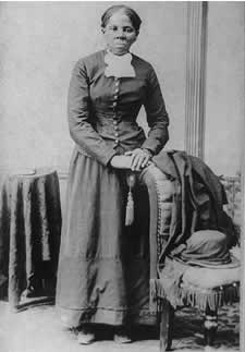 Harriet Tubman, full-length portrait, standing with hands on back of a chair