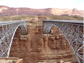 Photo of two bridges spanning a canyon of red rock.