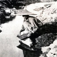 Photograph of a man panning in a river