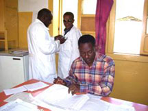 The photo shows a coworker reviewing TB/HIV registry books at Shashemene Hospital