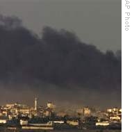 Smoke rises from Israeli bombardment over Gaza City as seen from Israel's border with Gaza, 12 Jan 2009