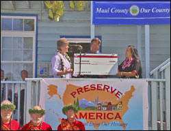 Cheryl Oliver, John Nau, Mayor Tavares and Allen Tom pose next to the Preserve America sign and the proclamation