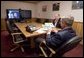 President George W. Bush is handed a map by Deputy Chief of Staff Joe Hagin, center, during a video teleconference with federal and state emergency management organizations on Hurricane Katrina from his Crawford, Texas ranch on Sunday August 28, 2005. White House photo by Paul Morse