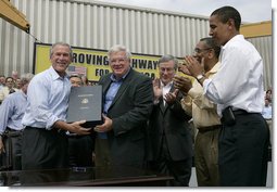 President George W. Bush holds the box after signing the Transportation Equity Act, with the help of Speaker of the House Dennis Hastert, R-Ill., at the Caterpillar facility in Montgomery, Ill., Wednesday, Aug. 10, 2005. Also pictured from left are Congressman Bill Thomas, R-Calif., Congressman Bobby Rush, D-Ill., and Senator Barack Obama, D-Ill. White House photo by Eric Draper