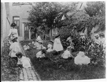 A woman and a group of children in a garden