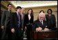 President George W. Bush stands by as John Danilovich signs appointment affidavits after being sworn in Tuesday, Dec. 20, 2005, as the new Chief Executive Officer of the Millennium Challenge Corporation during ceremonies at the U.S. Department of State. Looking on are Secretary of State Condoleezza Rice and members of Mr. Danilovich's family. White House photo by Paul Morse