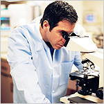 man looking into microscope