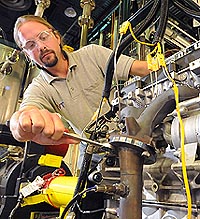 Argonne mechanical engineer Thomas Wallner adjusts Argonne's 'omnivorous engine,' an automobile engine that Wallner and his colleagues have tailored to efficiently run on blends of gasoline, ethanol and butanol