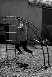 Photograph of a child playing on a jungle gym.