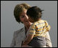 Mrs. Laura Bush smiles as she holds a child during a visit Friday, Nov. 21, 2008, to the San Clemente Health Center in San Clemente, Peru. The center serves an average of 80 patients a day in the town of 25,000 located six miles north of Pisco, the site of the August 2007, 8.0-magnitude earthquake. White House photo by Joyce N. Boghosian