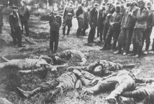 Membres d’un Einsatzkommando (unité mobile d'extermination) peu avant qu’ils exécutent un jeune juif. Les membres assassinés de sa famille sont étendus devant lui ; les hommes à gauche sont d’origine allemande et assistent le peloton. Slarow, Union soviétique, 4 juillet 1941.