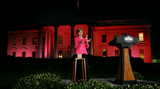 Mrs. Laura Bush applauds after pushing the button to flood the north front of the White House with a sea of pink, in honor of Breast Cancer Awareness Month, on Oct. 7, 2008. Bush addressed breast cancer survivors and advocates and members of the diplomatic corps just before the light display. The First Lady has encouraged worldwide efforts in preventing and curing a disease that is the leading cause of death in women. Each year more than 1.2 million people worldwide are diagnosed with breast cancer. The United States is working with countries in the Middle East, Europe and the Americas to empower women to take control of their health, raise awareness about the importance of prevention and early diagnosis, and support collaborative research to find a breast cancer cure. White House photo by Chris Greenberg