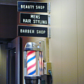 Barber pole outside the beautyand barber shop on the lower floor.