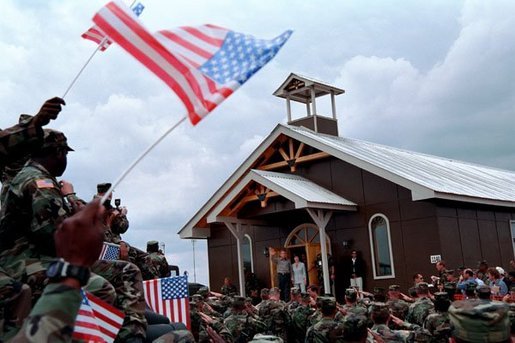 President George W. Bush and Laura Bush walk out of the chapel at Camp Bondsteel and are greeted by troops July 24, 2001 in Kosovo, Federal Republic of Yugoslavia. White House photo by Eric Draper.