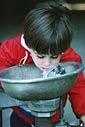 Image of young boy drinking from a water fountain.