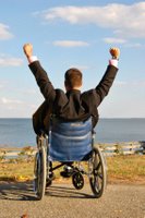 a man in a wheelchair raises his hands triumphantly