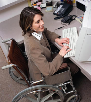 Woman who uses a wheelchair sits at a computer