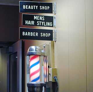 Barber pole outside of beauty and barber shop.