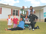 Family on front lawn of home