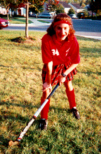A girl playing field hockey.