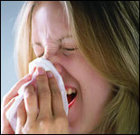 Photo: A woman sneezing.