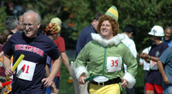 Never know who’ll compete in the Challenge Relay. Dr. David Robinson (l) is chased by Buddy the Elf.