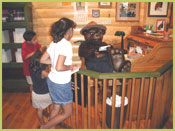 Picture of Smokey Bear reading his fan mail; children are viewing Smokey in the Information Center, located on the bottom floor of the Yates building.