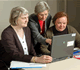 Three Women Around a Computer