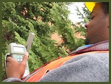 Photograph of FIA forester Joseph, determining plot's location using Global Positioning System.