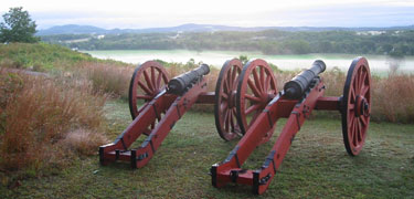 Early morning light shows two cannons overlooking a foggy Hudson River Valley from American positions on Bemis Heights.