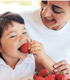 Mother Watching Child Eat Strawberries