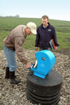 Sweeney shows NRCS Soil Conservationist Ryan Gerlich how  pumps work to provide water to cows in three of seven paddocks -- Mike Sweeney used a tile line from his pond and an ag waterway to animal powered nose pumps (NRCS photo by Jason Johnson – click to enlarge)