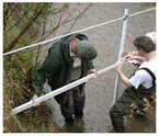 Photo of men performing a river assessment