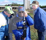 (from left) NRCS civil engineering technician Michael Hemmann, Minnesota NRCS State Conservationist William Hunt, and landowner Dan Atkinson stake out the corners of an agricultural waste facility using the Robotic Total Station (NRCS photo by NRCS soil conservationist Jaime Schaunaman -- click to enlarge)