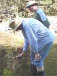 EAC student Robert Gabittas looks over Dave Henson’s shoulder at a water quality reading near Honeymoon on Upper Eagle Creek (EAC photo -- click to enlarge)