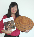 Lisa Woo Shanks holds a copy of Indian Baskets of Central California and an early basket from that region