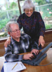 An older man and woman using a laptop computer.