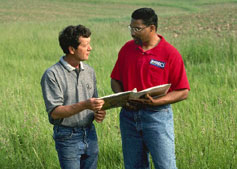 consultant and farmer in field